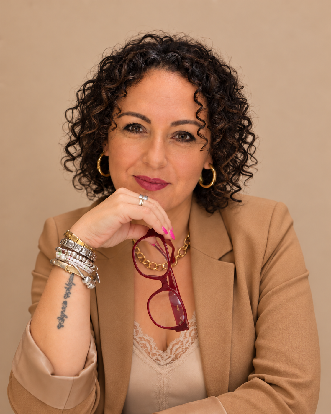 Retrato de Mari Carmen Zambrano con chaqueta camel y sus gafas granate en la mano